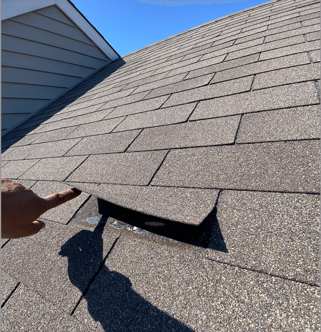 inspector noticing a loose shingle during a roof inspection in Bloomington IN 2022
