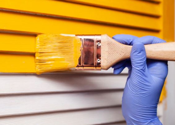 crew member painting outside area with brush